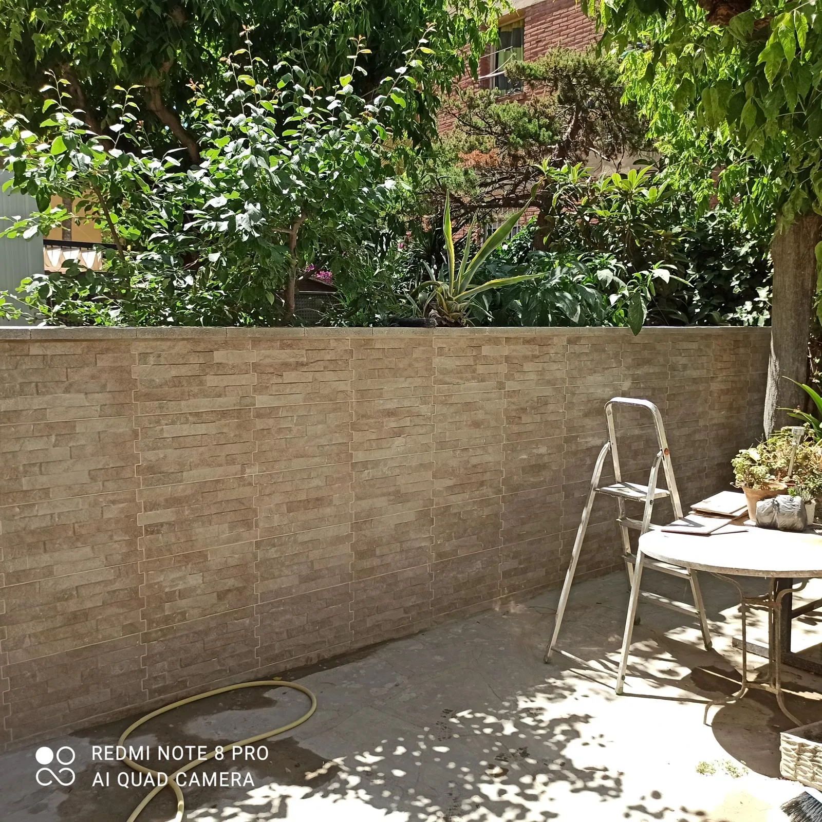 Patio con muro nuevo y aplacado de piedra: después de la reforma